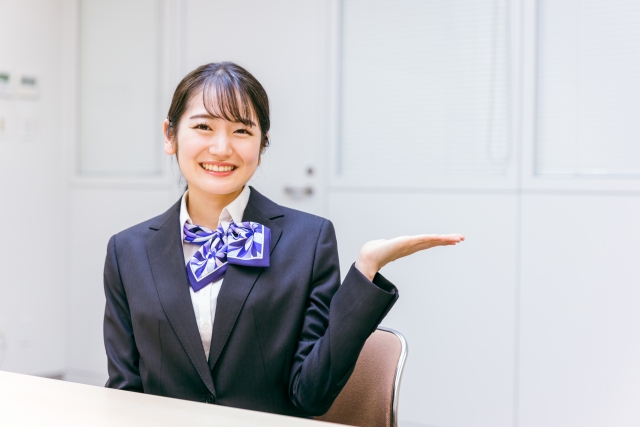 手を曲げて案内している女性
